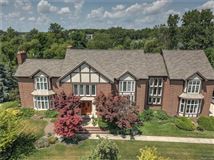 THIS MAJESTIC TUDOR SITS ON A LUSH PRIVATE LOT WITH PRIVACY AND NATURE